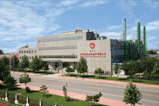 Beijing Tongmei Xtal Technology facility: a multi-story production building with green processing stacks, viewed from the tree-lined street